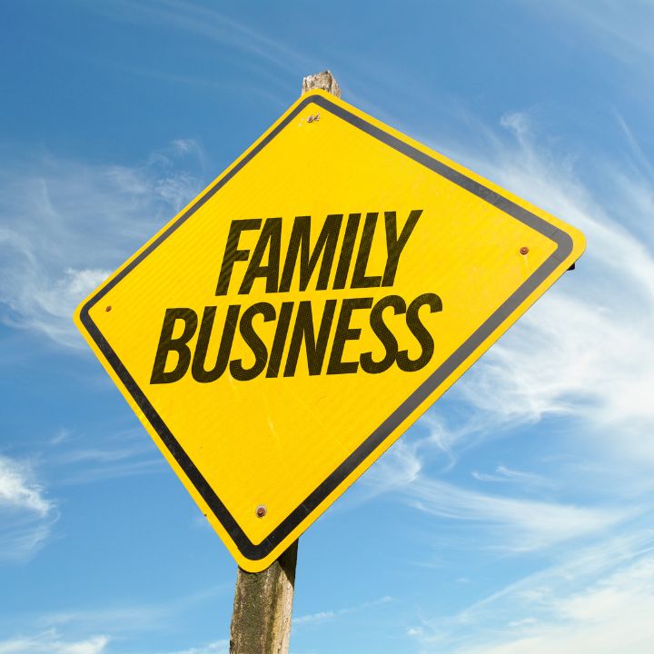 Yellow sign that says "family business" against a blue sky